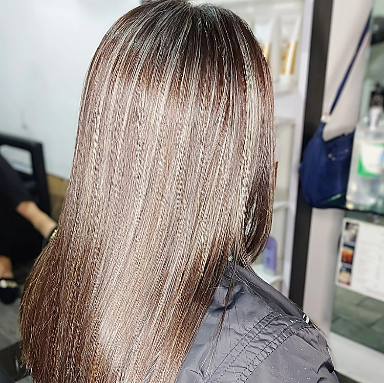 Cabello largo y lacio con mechas rubias sobre base castaña, de espaldas