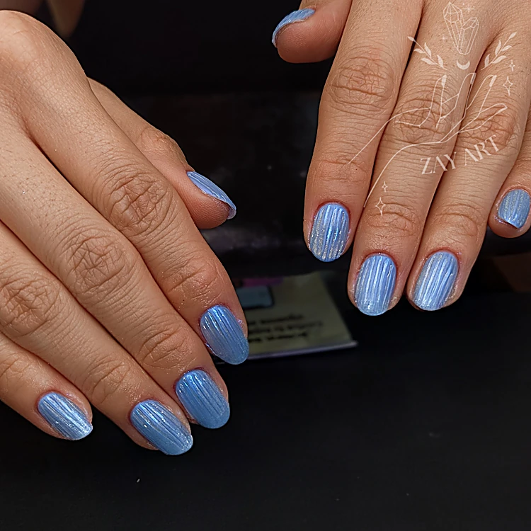 Uñas cortas en azul cielo con líneas verticales en relieve sobre fondo negro