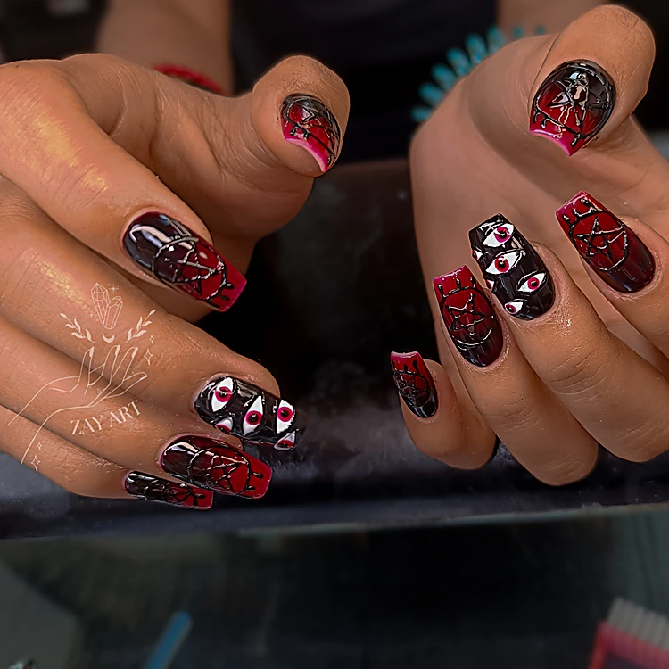 Uñas cuadradas en guinda y negro con ojos pintados y telarañas en rojo