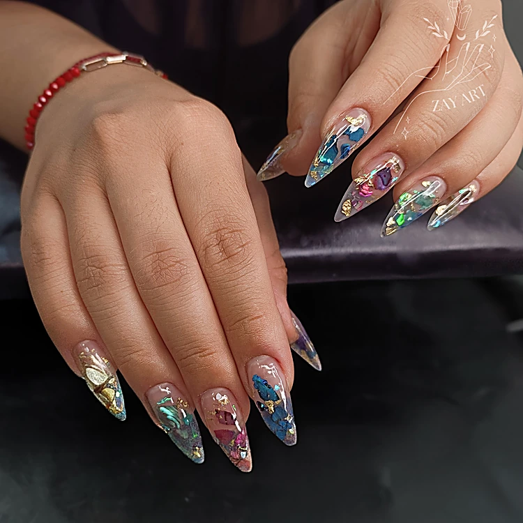 Uñas almendradas translúcidas con láminas holográficas plateadas