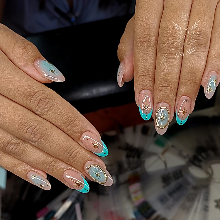 Uñas almendradas nude con punta turquesa y estrellas doradas
